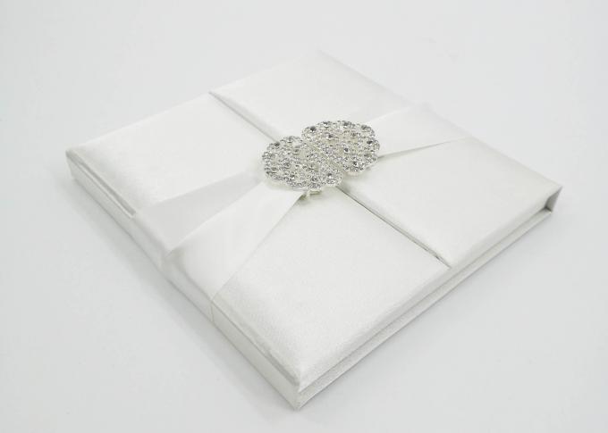 Κομψή άσπρη μεταξιού γαμήλια πρόσκληση κιβωτίων δώρων χαρτονιού παρούσα με το τόξο/την πόρπη